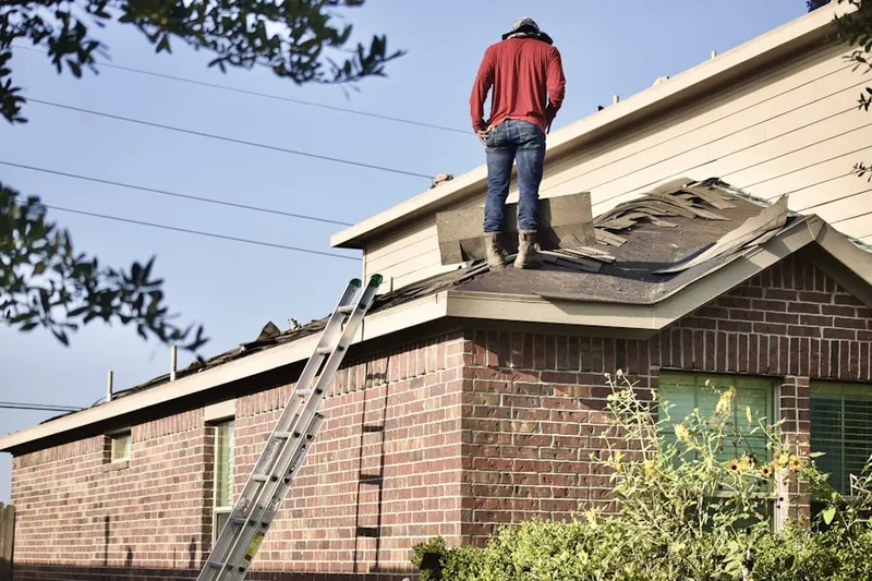 Professional roofer working on a residential roof in Elon